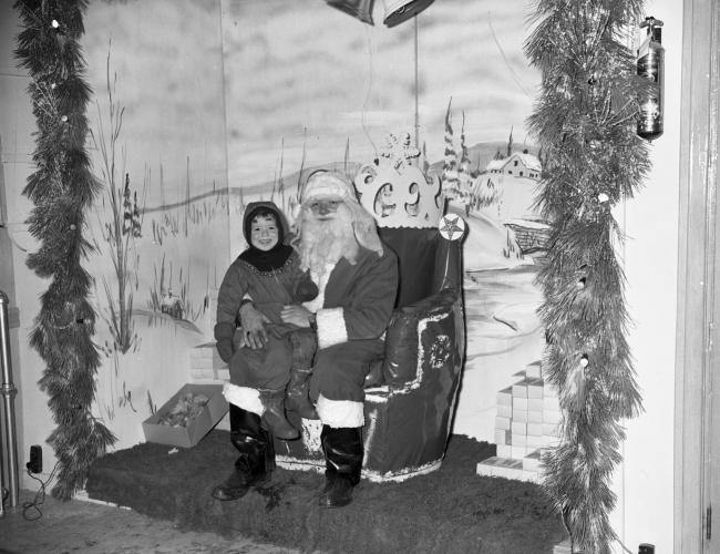 Enfant assis sur le père noël